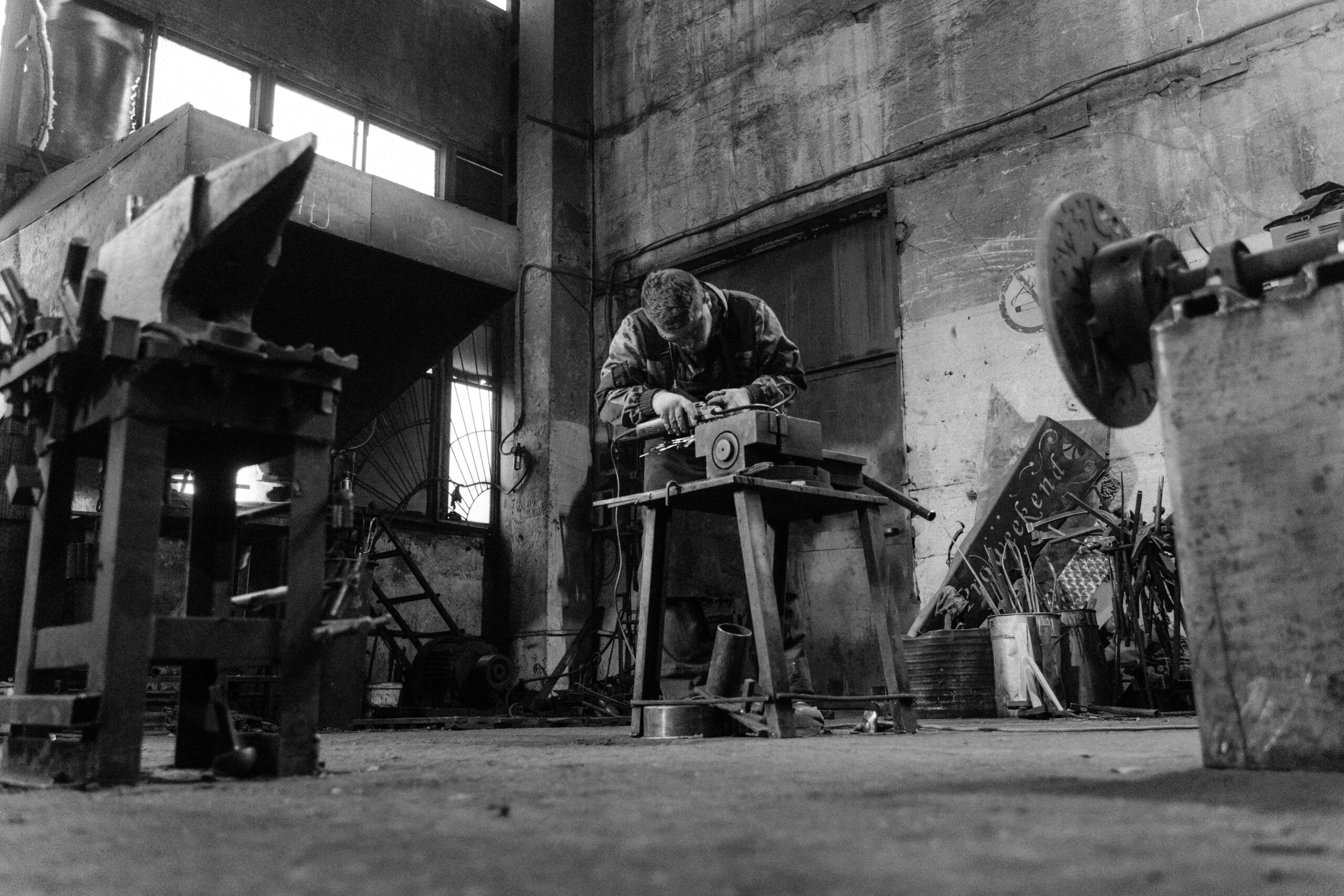 A craftsman works diligently in a vintage industrial workshop.